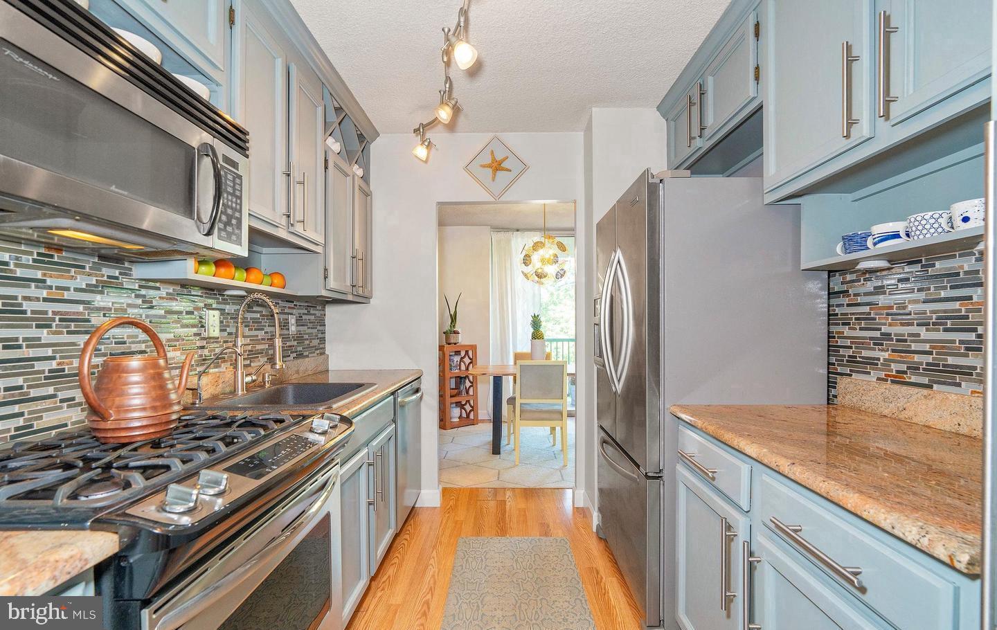 a kitchen with stainless steel appliances granite countertop a stove and a refrigerator