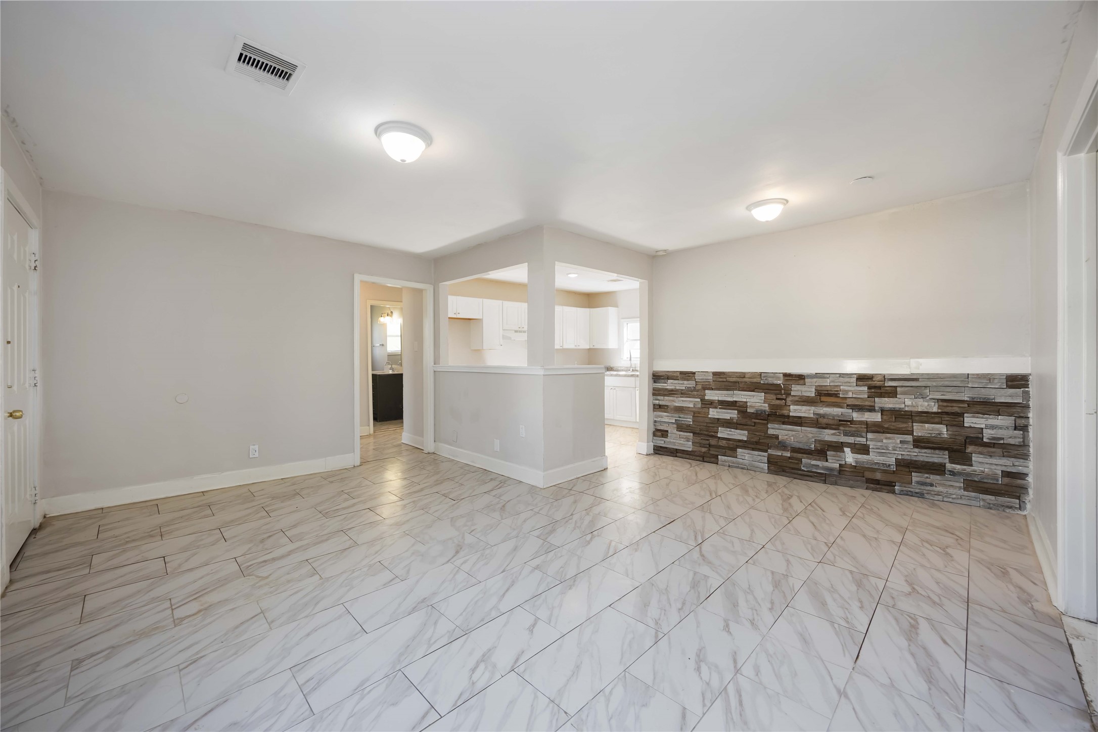 5934 Belcrest Street Houston, TX 77033 - Photo 3 of 17 an empty room with kitchen view and wooden floor