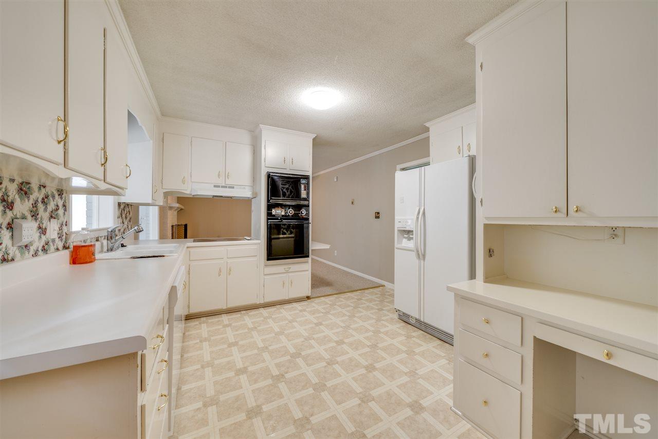 3307 Baugh Street Raleigh, NC 27604 - Photo 5 of 27 a kitchen with stainless steel appliances a refrigerator sink stove and white cabinets