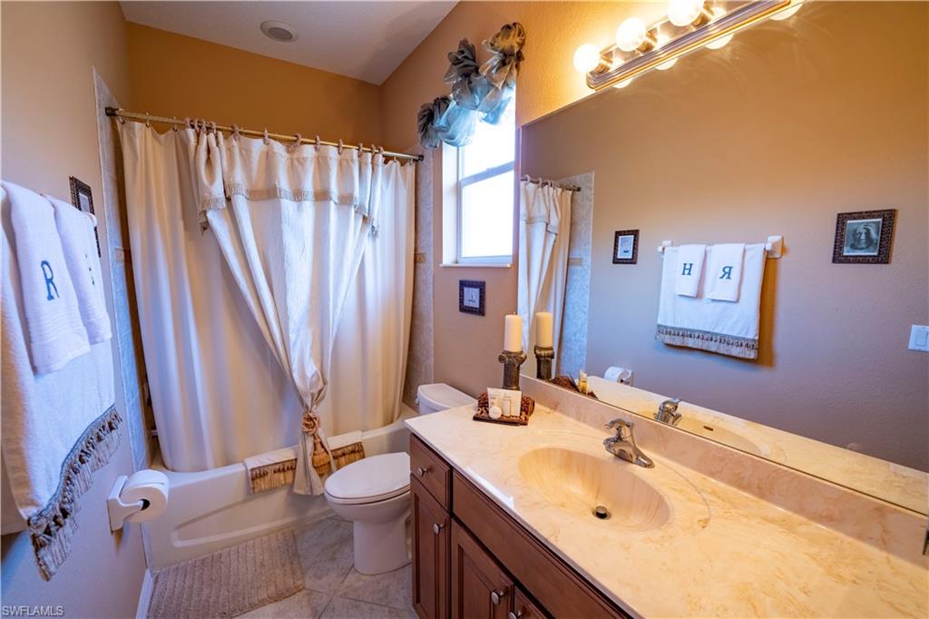 20007 Larino Loop Estero, FL 33928 - Photo 17 of 27 a bathroom with a double vanity sink toilet and shower