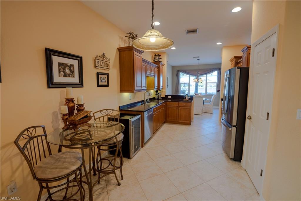 20007 Larino Loop Estero, FL 33928 - Photo 8 of 27 a kitchen with stainless steel appliances a table and chairs
