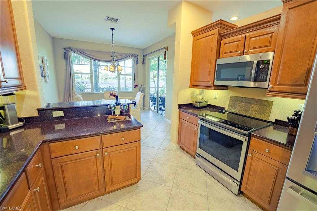 20007 Larino Loop Estero, FL 33928 - Photo 10 of 27 a kitchen with stainless steel appliances granite countertop a stove and a sink