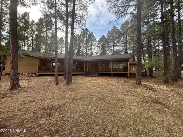 a view of a house with a yard and tree