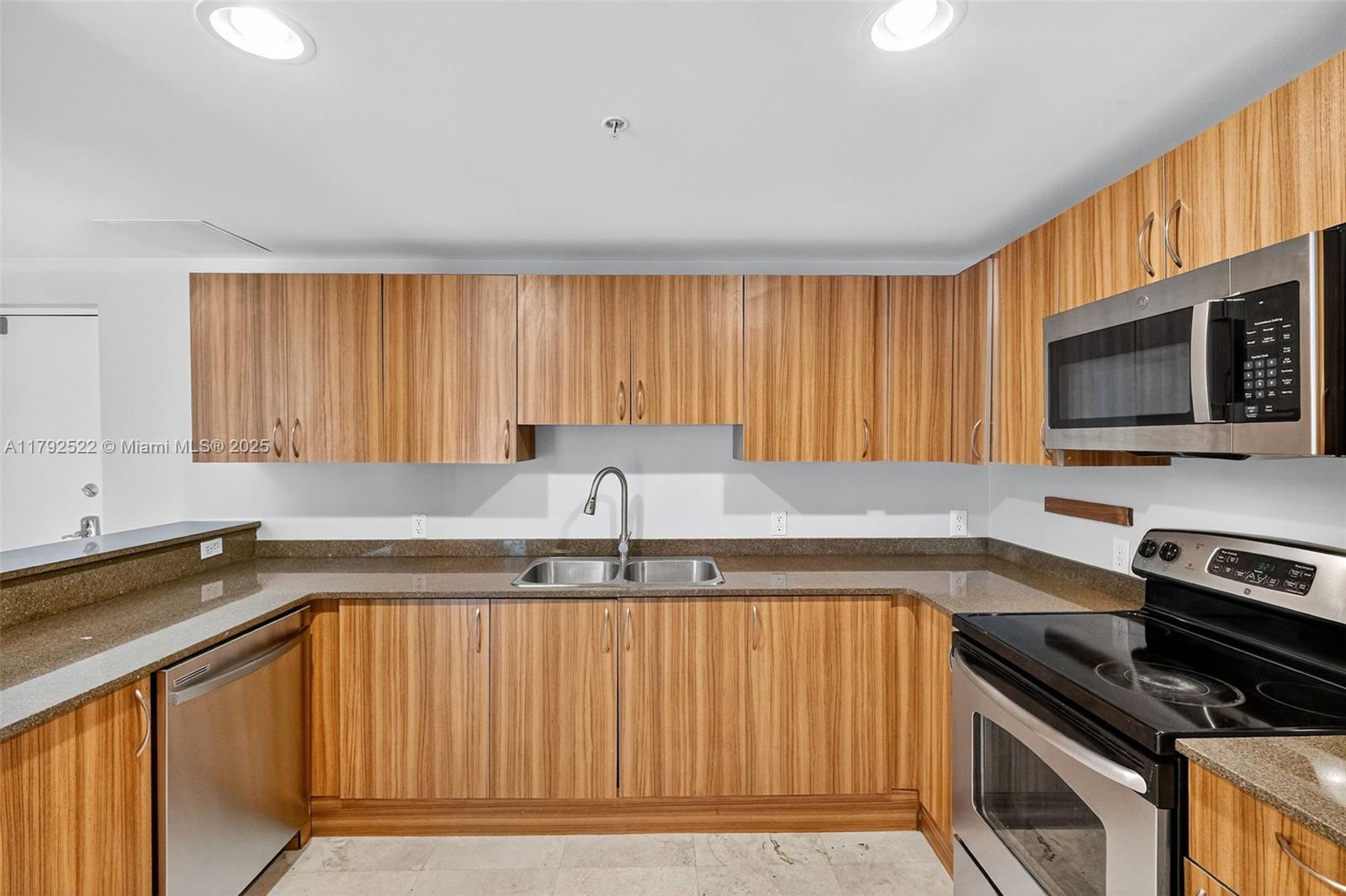 6305 Indian Creek Drive, Unit 3F Miami Beach, FL 33141 - Photo 19 of 60 a kitchen with granite countertop a stove a sink and a microwave