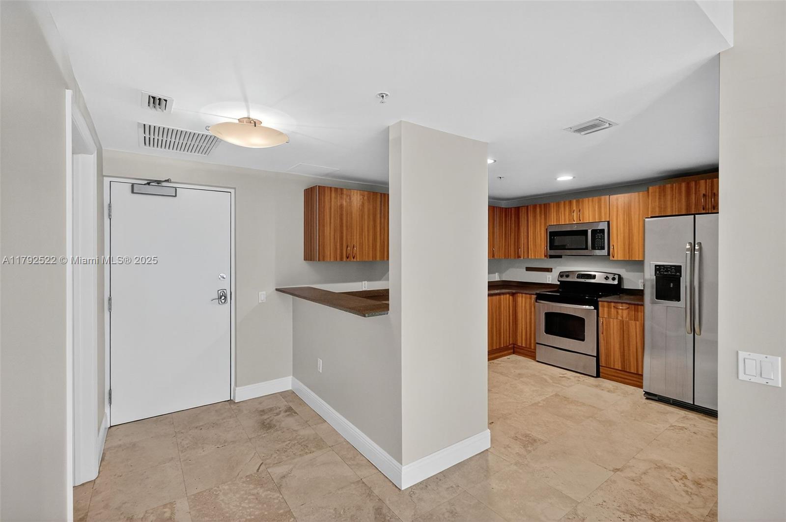 6305 Indian Creek Drive, Unit 3F Miami Beach, FL 33141 - Photo 20 of 60 a kitchen with stainless steel appliances kitchen island granite countertop a refrigerator and a stove top oven