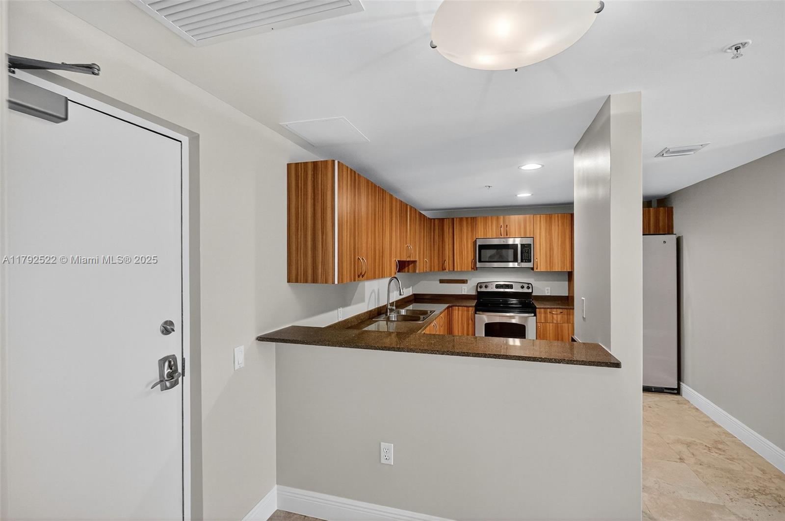 6305 Indian Creek Drive, Unit 3F Miami Beach, FL 33141 - Photo 21 of 60 a kitchen with a sink and a refrigerator