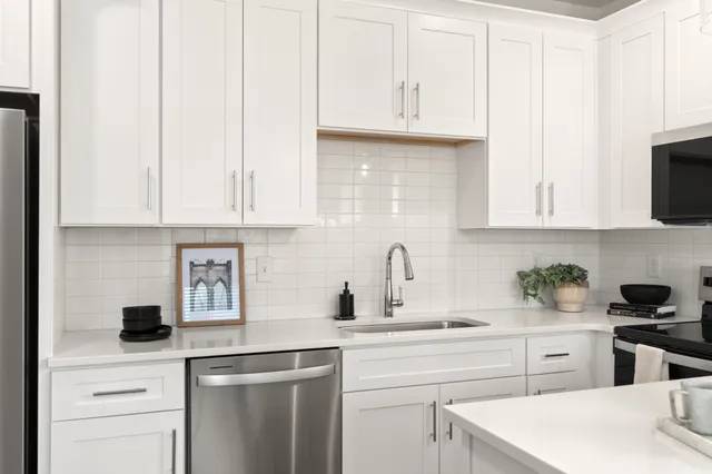 a kitchen with white cabinets and white appliances
