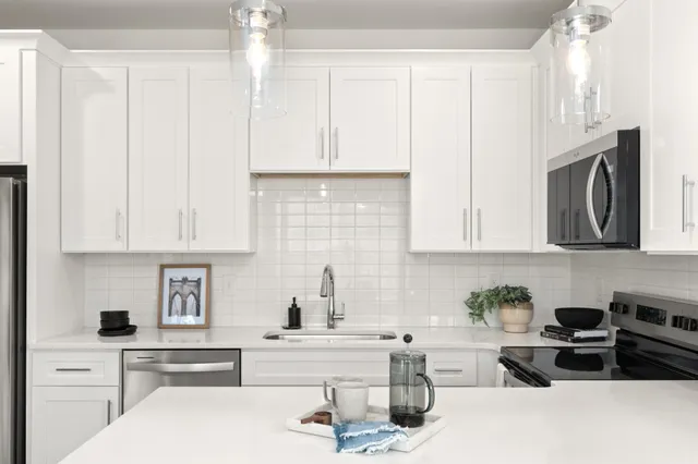 a kitchen with stainless steel appliances granite countertop a sink a stove and cabinets