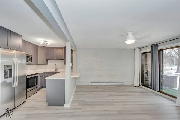 a view of kitchen with stainless steel appliances granite countertop refrigerator stove microwave and cabinets