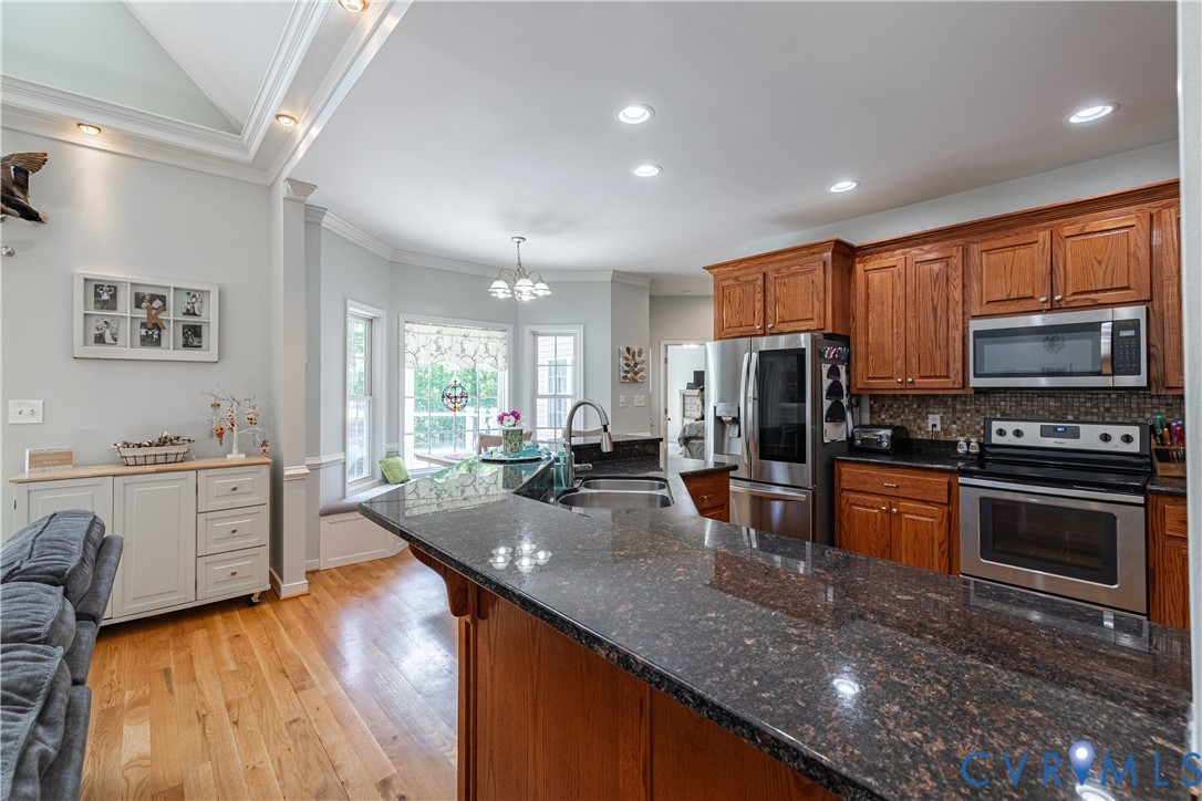 4789 Tatum Road Disputanta, VA 23842 - Photo 14 of 46 a large kitchen with kitchen island a stove a sink a refrigerator dining table and chairs