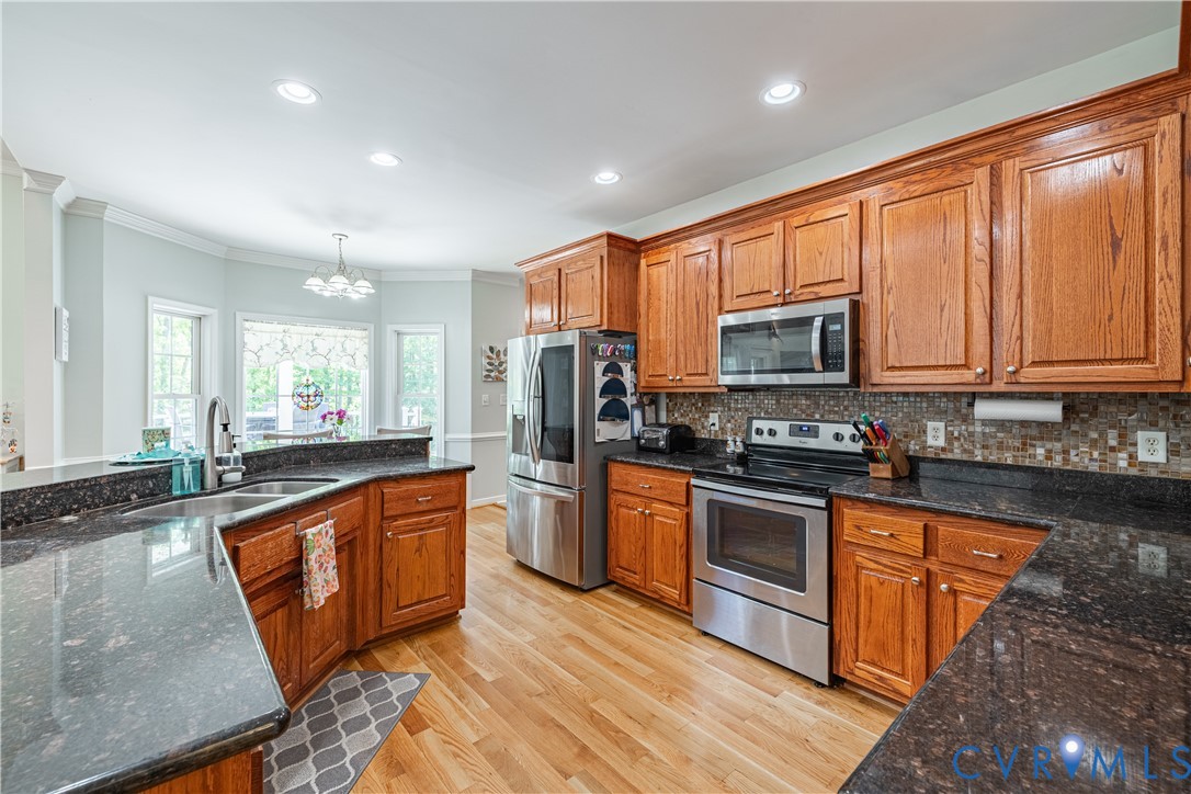 4789 Tatum Road Disputanta, VA 23842 - Photo 16 of 46 a large kitchen with stainless steel appliances granite countertop a stove a sink and a microwave
