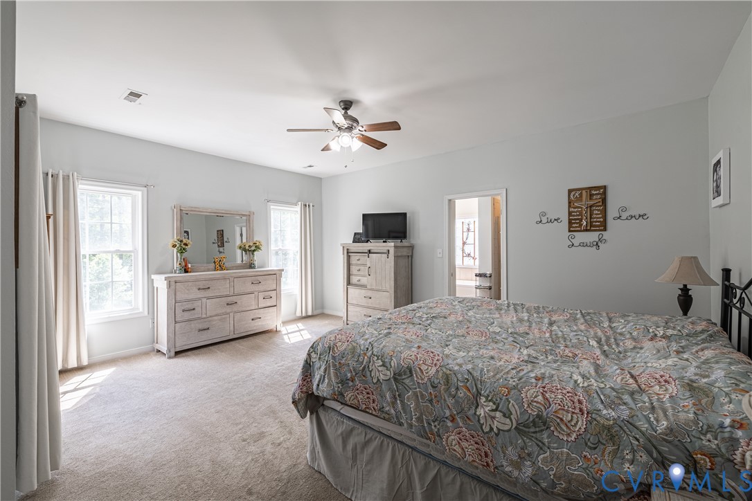 4789 Tatum Road Disputanta, VA 23842 - Photo 22 of 46 a bedroom with a large bed and a chandelier