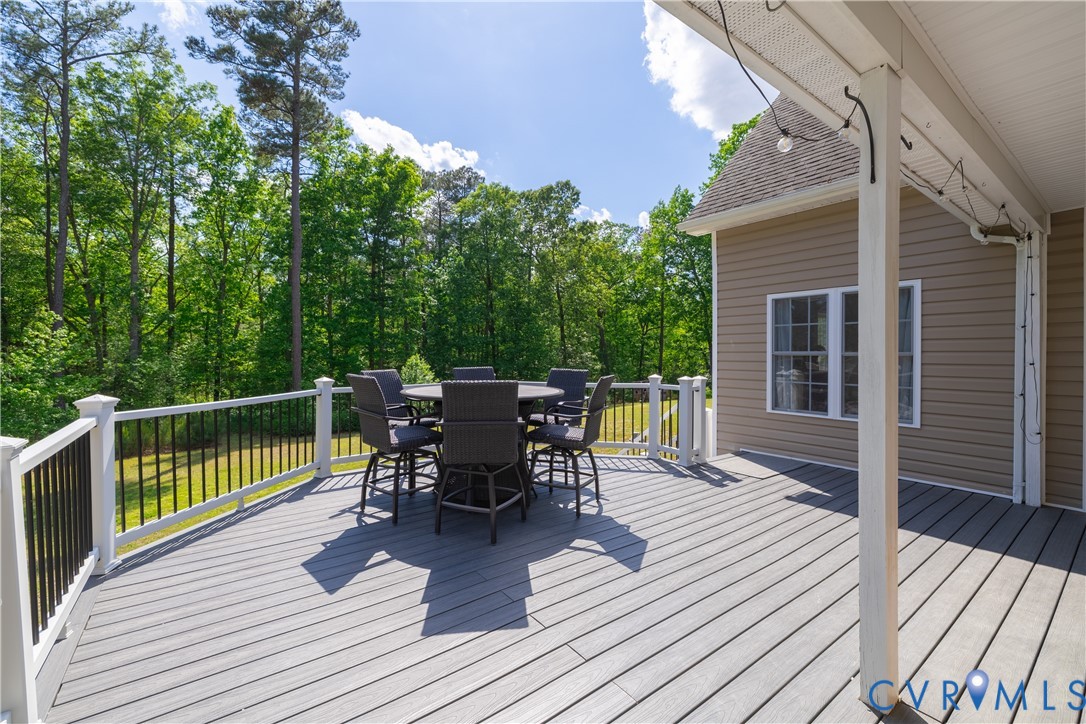 4789 Tatum Road Disputanta, VA 23842 - Photo 32 of 46 a view of a roof deck with table and chairs floor to ceiling window with wooden floor