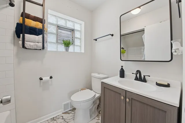 a bathroom with a toilet sink and mirror