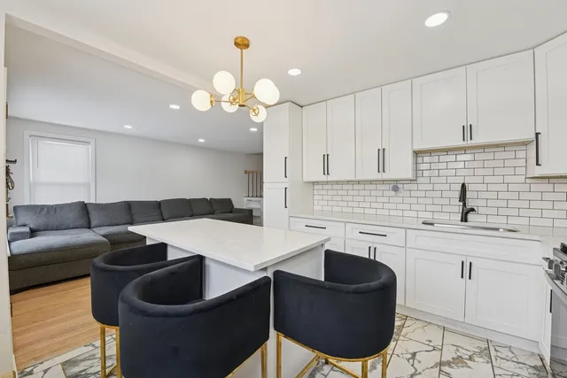 a kitchen with a table chairs sink and cabinets