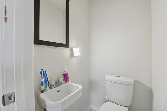 a bathroom with a sink mirror and toilet