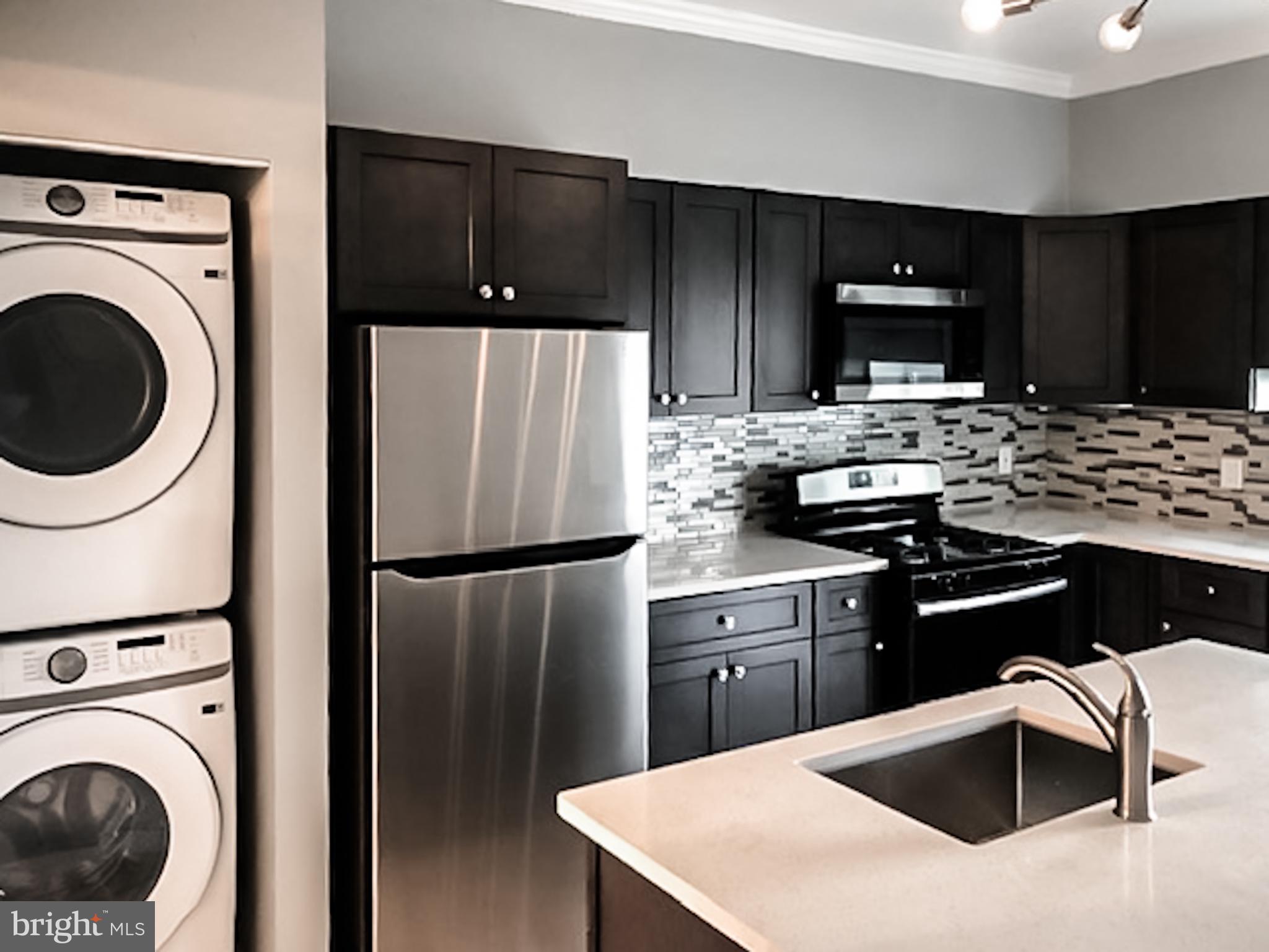 a kitchen with stainless steel appliances a refrigerator sink and cabinets