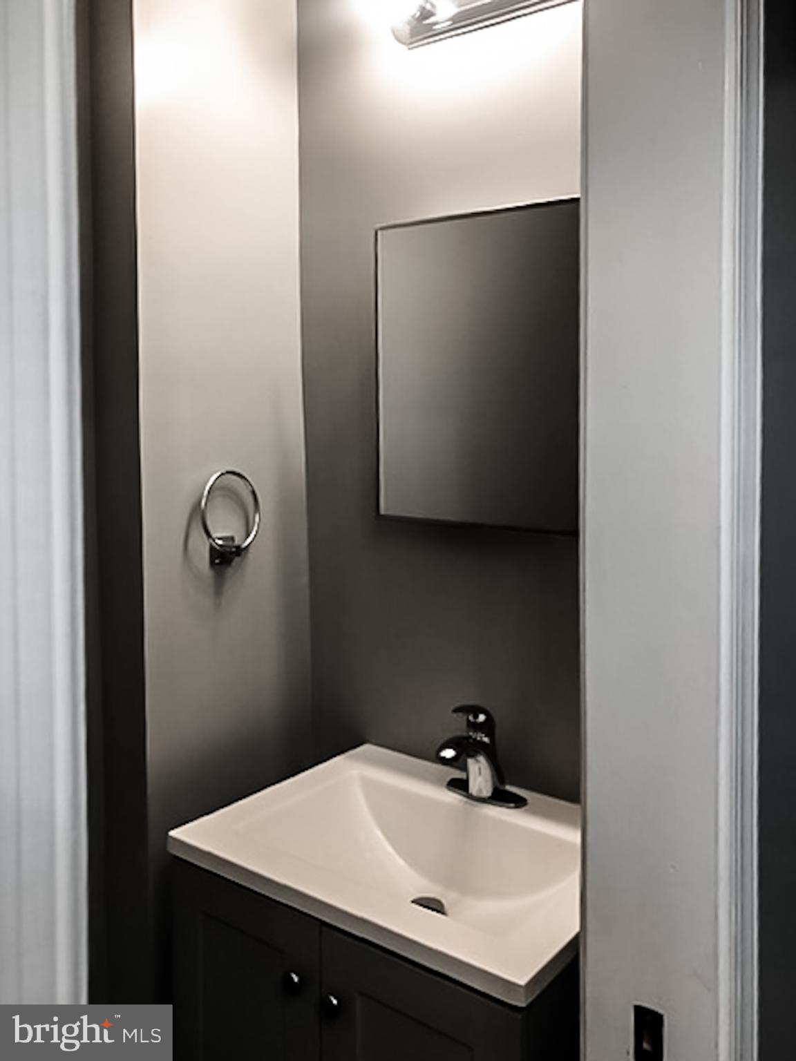 1673 Darley Avenue Baltimore, MD 21213 - Photo 17 of 17 a bathroom with a sink and mirror