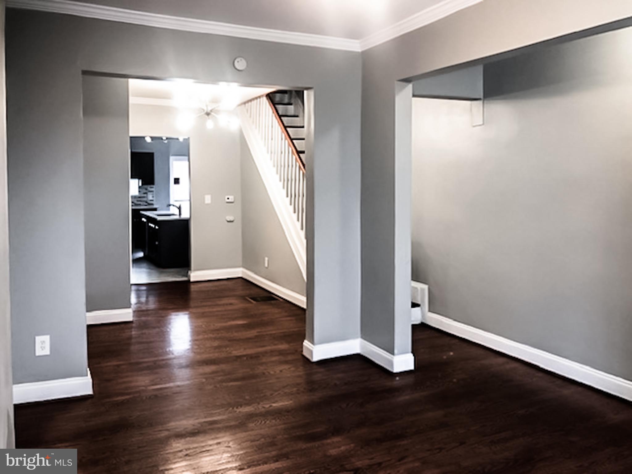 1673 Darley Avenue Baltimore, MD 21213 - Photo 4 of 17 wooden floor in an empty room with a window