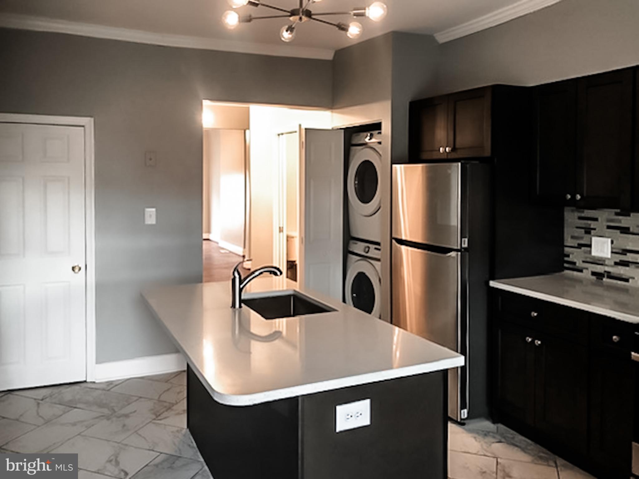1673 Darley Avenue Baltimore, MD 21213 - Photo 5 of 17 a kitchen with refrigerator a sink and cabinets