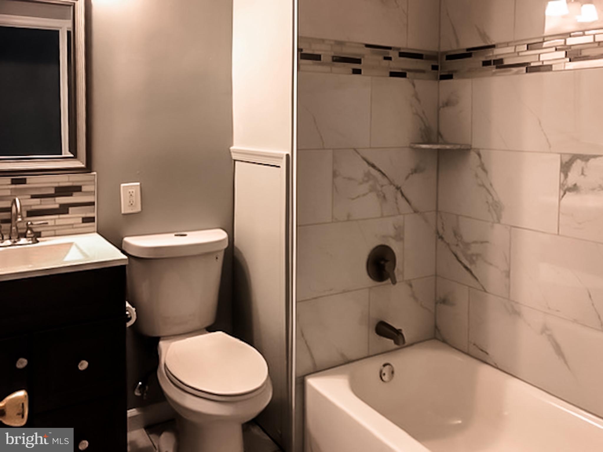 1673 Darley Avenue Baltimore, MD 21213 - Photo 10 of 17 a bathroom with a sink and mirror with toilet