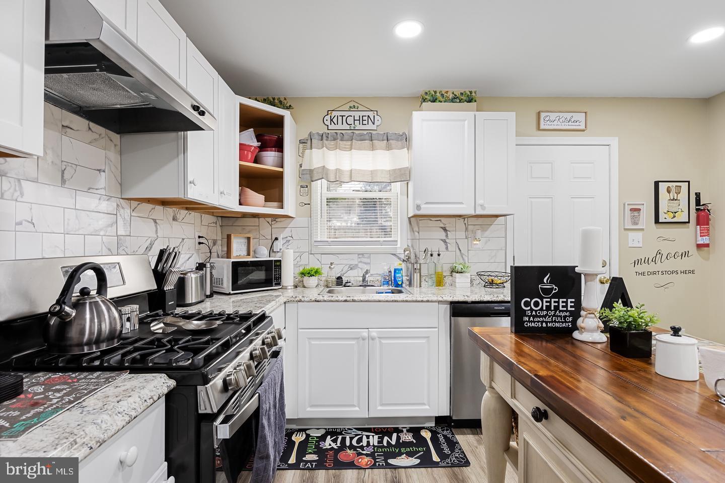 a kitchen with granite countertop a stove sink and cabinets