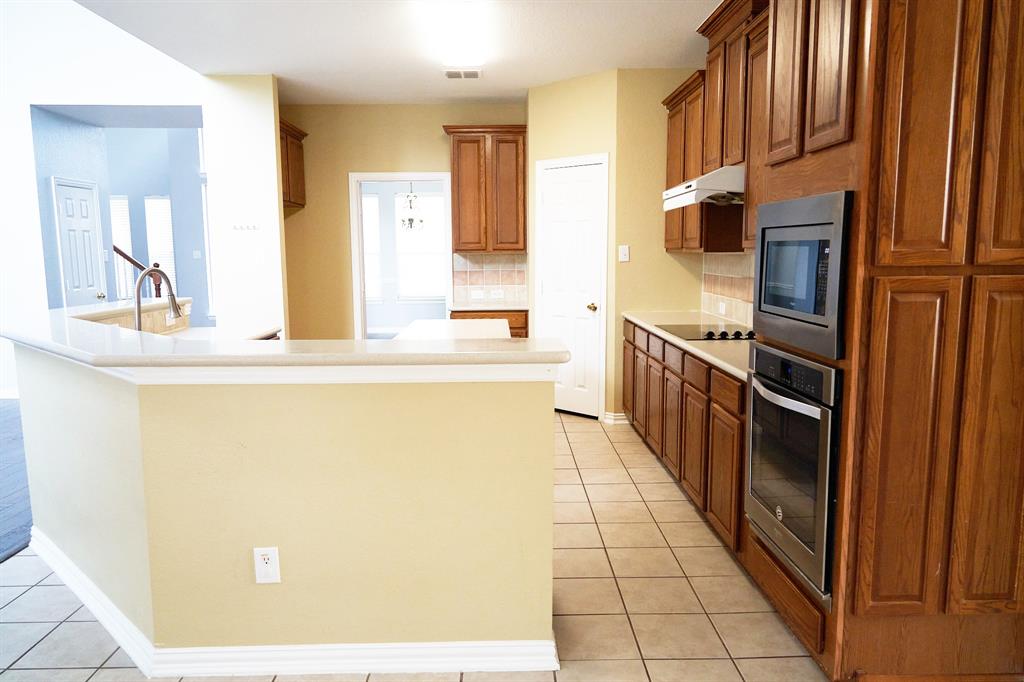 4469 Big Sky Drive Plano, TX 75024 - Photo 14 of 39 a kitchen with stainless steel appliances a refrigerator and a stove