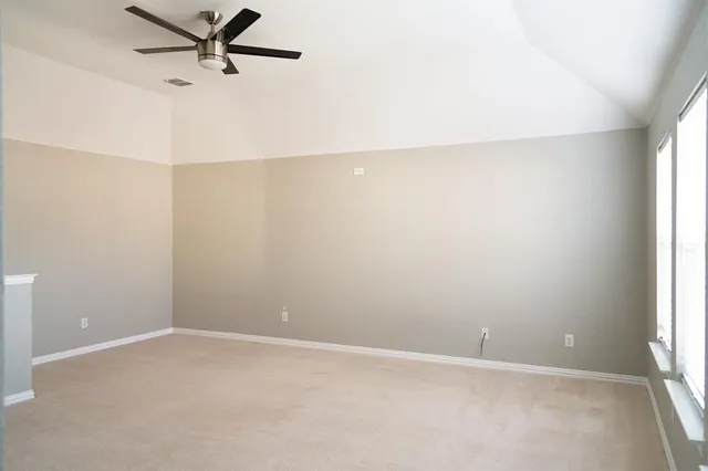 an empty room with a window and a fan
