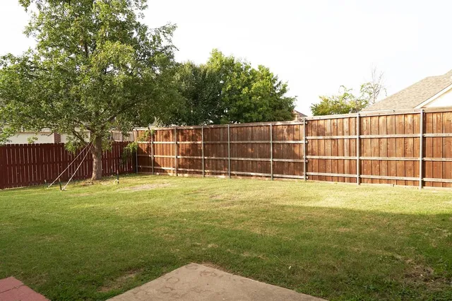 a view of a yard with a wooden fence