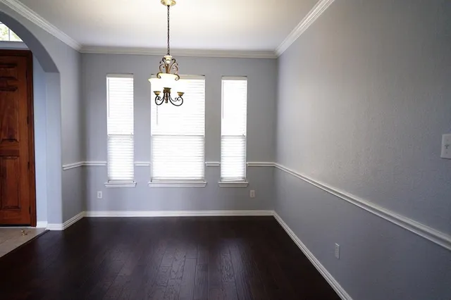 a room with wooden floor and windows