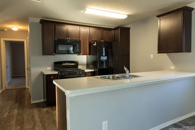 a kitchen with kitchen island a counter top space a sink and stainless steel appliances