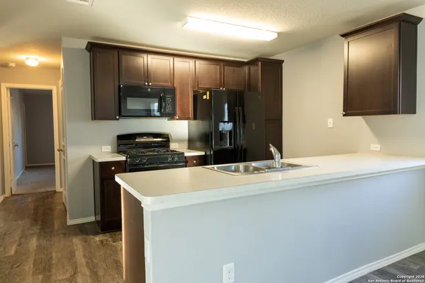 a kitchen with kitchen island a counter top space cabinets and stainless steel appliances