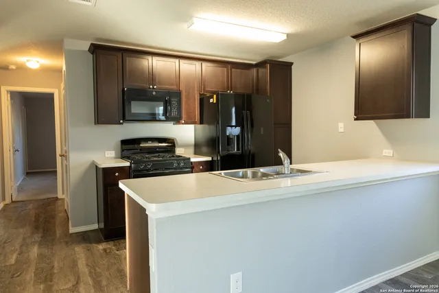 a kitchen with kitchen island a counter top space cabinets and stainless steel appliances