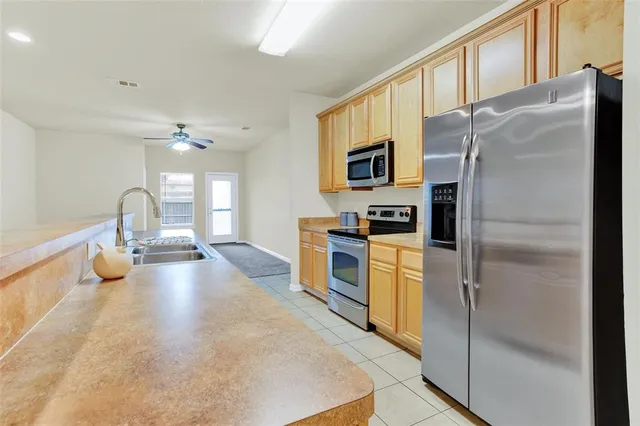 a kitchen with stainless steel appliances a refrigerator sink and stove