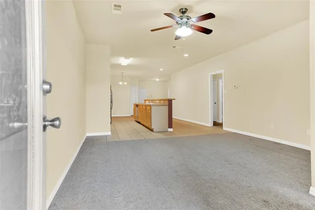 a view of a livingroom with a ceiling fan and a kitchen