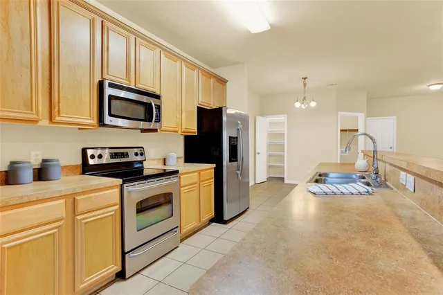 a kitchen with stainless steel appliances granite countertop a stove a sink and a refrigerator