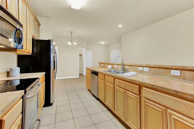 a large kitchen with stainless steel appliances a sink and cabinets