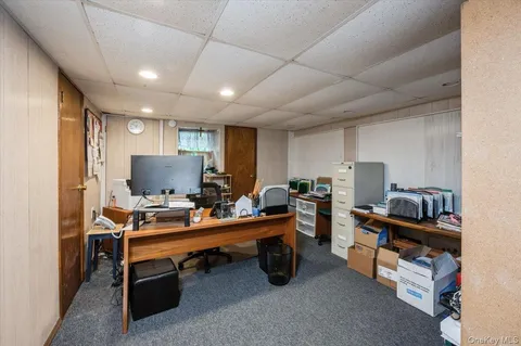 a view of a workspace with furniture and a window