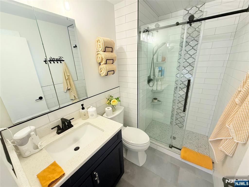 33 Willow Wood Court, Unit 2 East Rutherford, NJ 07073 - Photo 16 of 17 a bathroom with a sink a toilet and shower