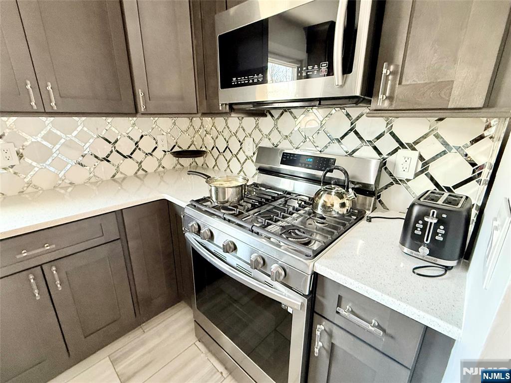33 Willow Wood Court, Unit 2 East Rutherford, NJ 07073 - Photo 2 of 17 a kitchen with a stove and a microwave