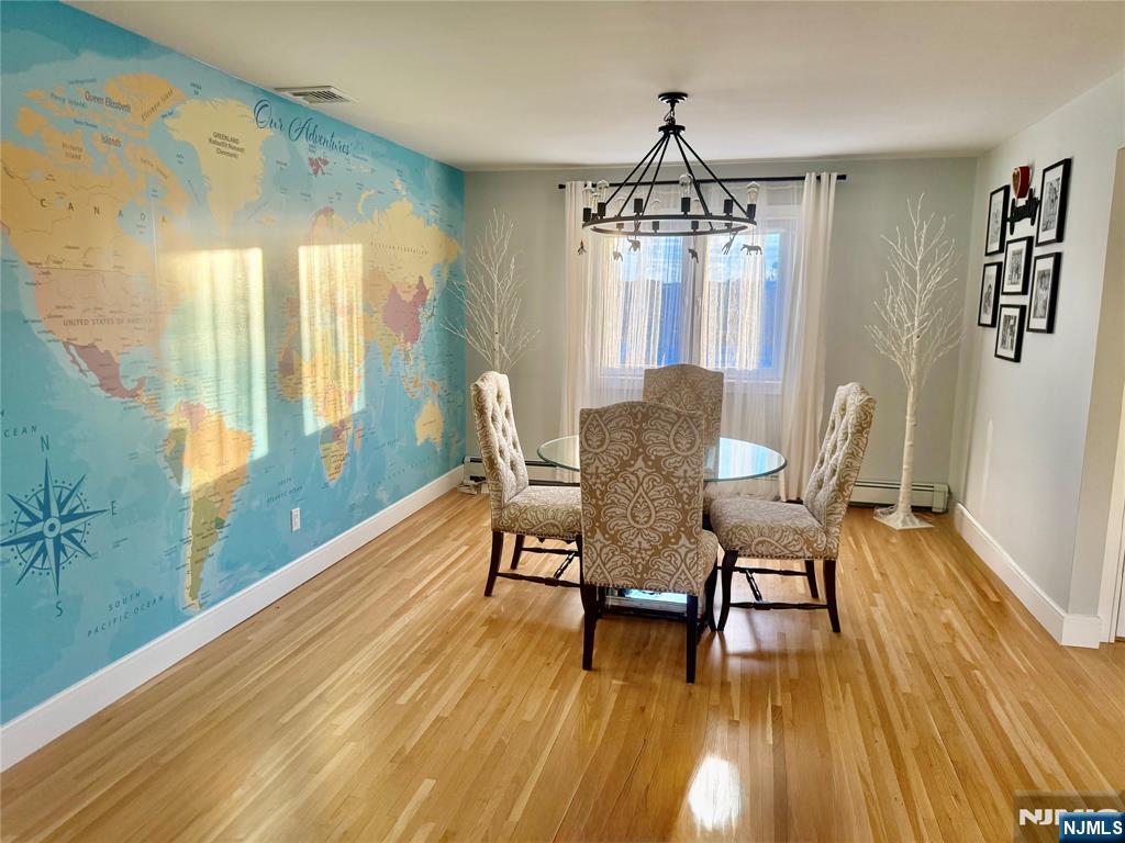 33 Willow Wood Court, Unit 2 East Rutherford, NJ 07073 - Photo 8 of 17 a dining room with wooden floor a chandelier a glass table and chairs