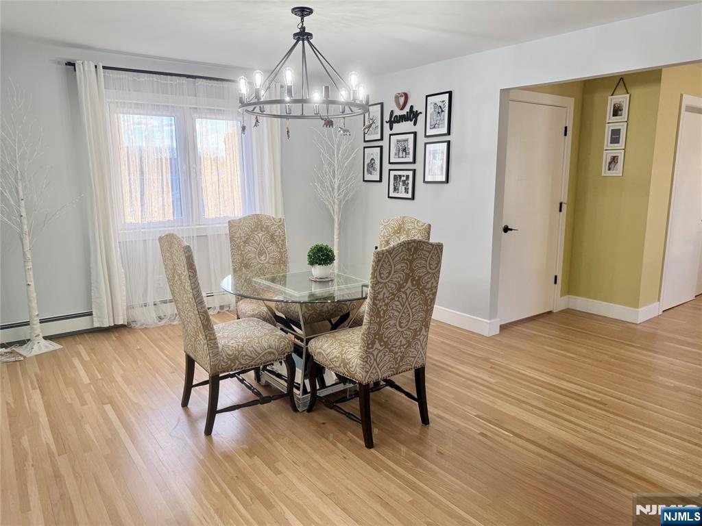 33 Willow Wood Court, Unit 2 East Rutherford, NJ 07073 - Photo 9 of 17 a view of a dining room with furniture wooden floor and chandelier