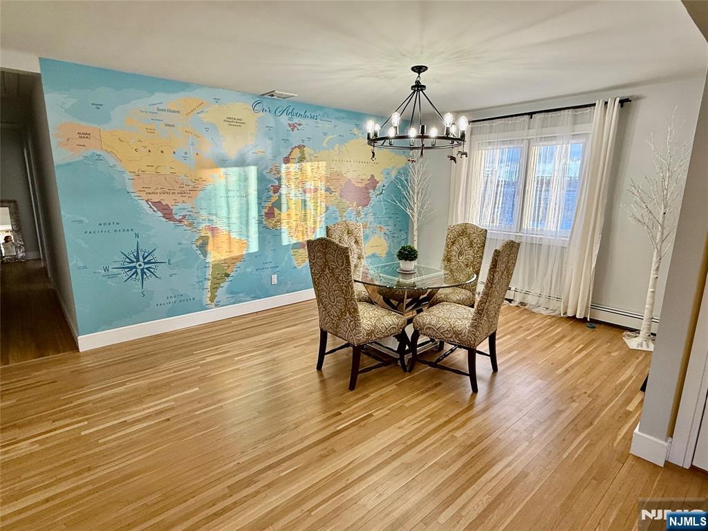33 Willow Wood Court, Unit 2 East Rutherford, NJ 07073 - Photo 10 of 17 a view of a dining room with furniture a chandelier and wooden floor