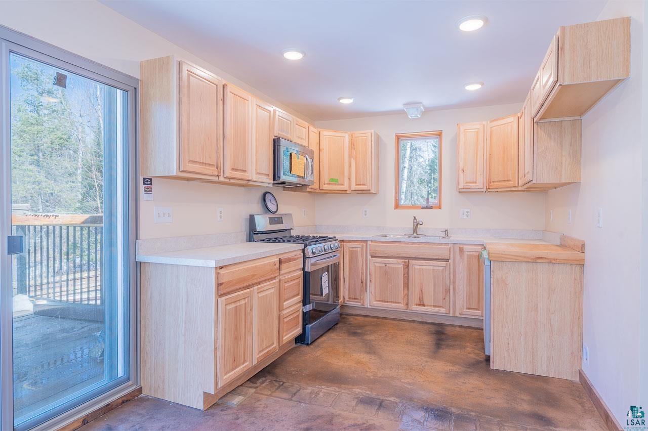 7579 Thumbnail Drive Embarrass, MN 55732 - Photo 3 of 21 Kitchen with stainless steel appliances, sink, and light brown cabinetry