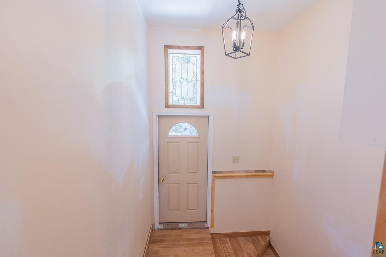 7579 Thumbnail Drive Embarrass, MN 55732 - Photo 6 of 21 Doorway to outside featuring plenty of natural light, light hardwood / wood-style flooring, and a notable chandelier