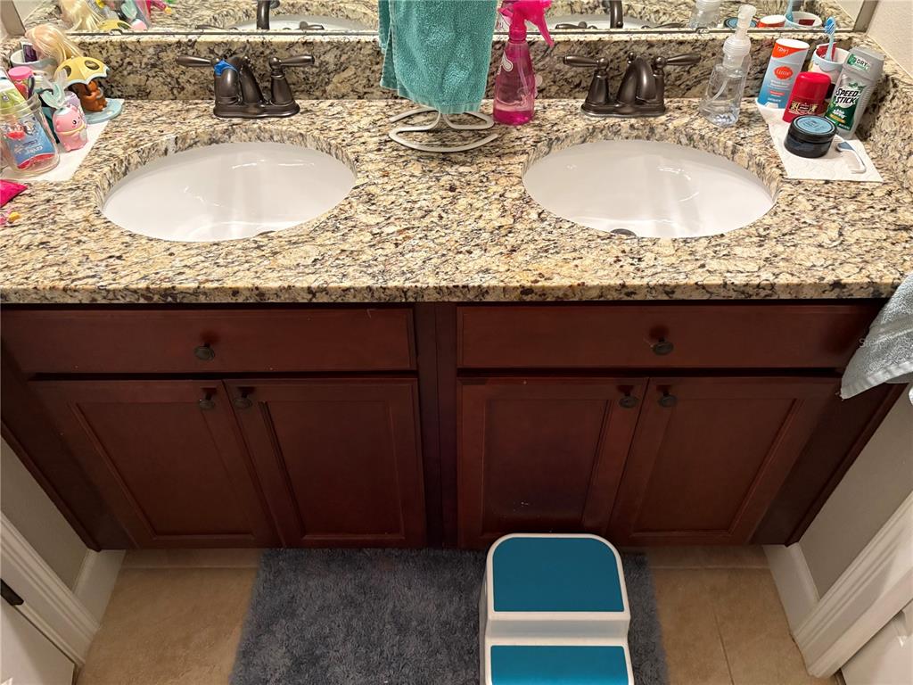 709 Calabria Way Howey-in-the-Hills, FL 34737 - Photo 14 of 26 a bathroom with a granite countertop sink and a mirror