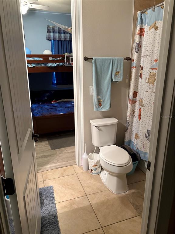 709 Calabria Way Howey-in-the-Hills, FL 34737 - Photo 17 of 26 a bathroom with a toilet and a shower