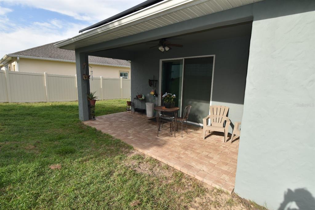 709 Calabria Way Howey-in-the-Hills, FL 34737 - Photo 21 of 26 a view of a backyard with chair and tables