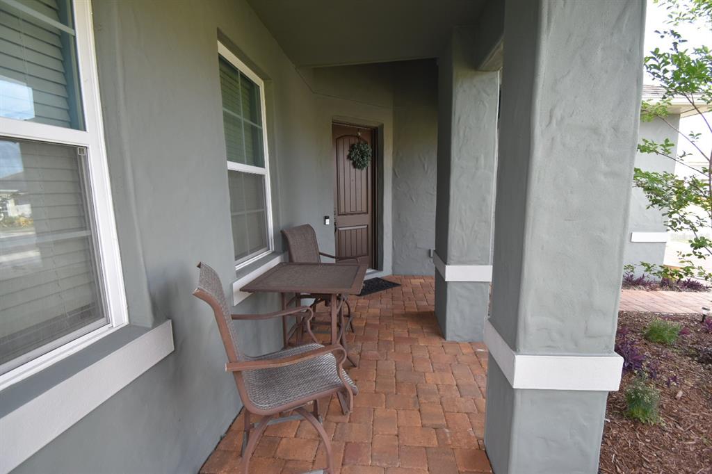 709 Calabria Way Howey-in-the-Hills, FL 34737 - Photo 4 of 26 a patio with table and chairs and potted plants