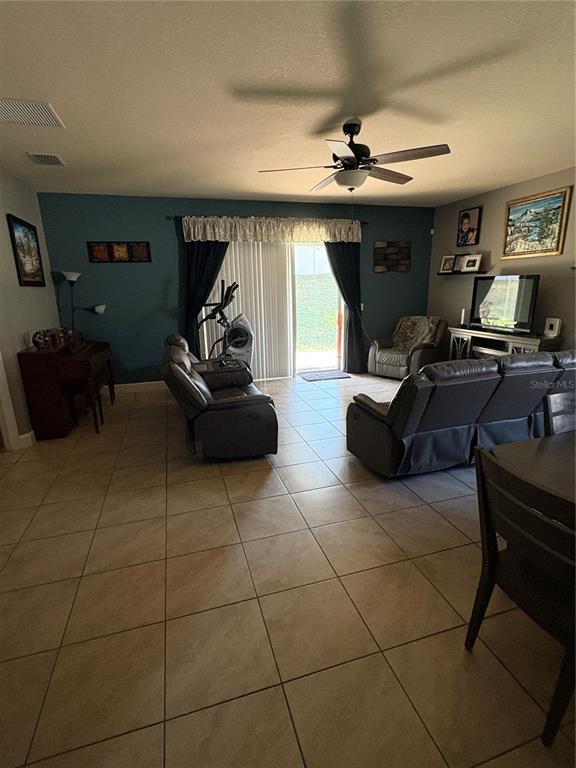 709 Calabria Way Howey-in-the-Hills, FL 34737 - Photo 9 of 26 a living room with furniture and a chandelier